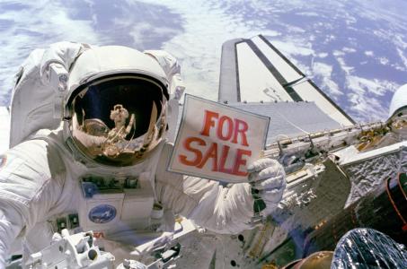 拿着出售标志墙纸的宇航员